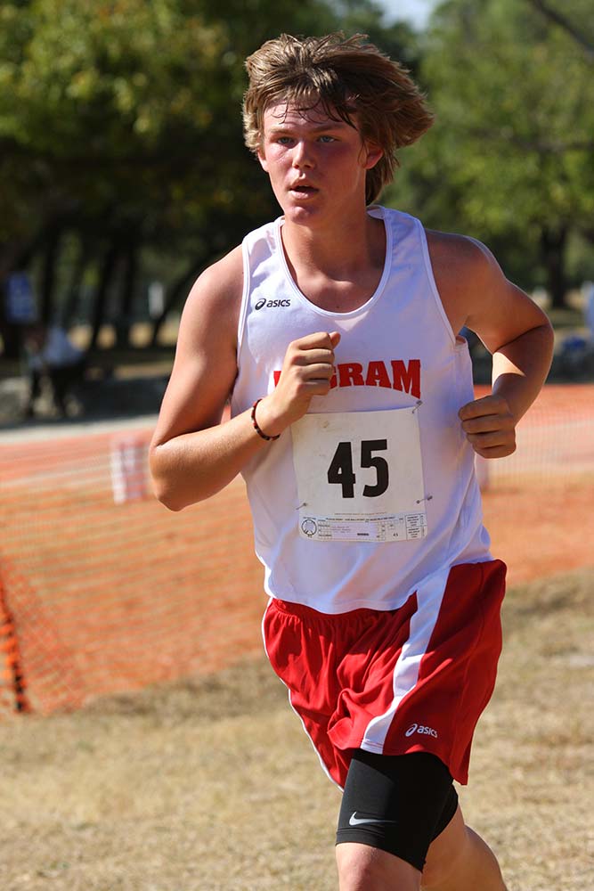 Ashton mid-stride at a cross-country meet in the red-and-white Ingram singlet, race bib number 45