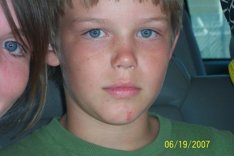 Window-light close-up of Ashton in the back seat of the car, freckles and clear blue eyes, date-stamped 06/19/2007